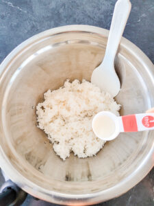 adding the vinegar mixture to cooked rice